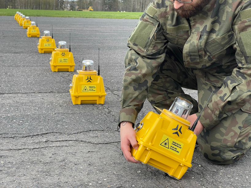 Soldier deploying S4GA portable airfield light on a runway